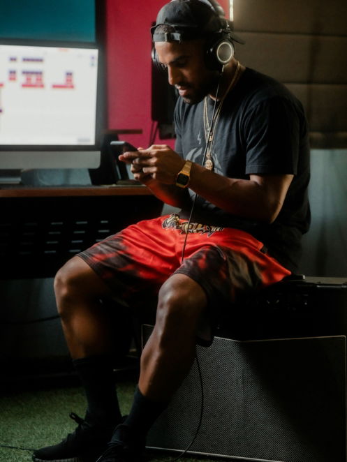 man in blue crew neck t-shirt and red shorts sitting on black chair